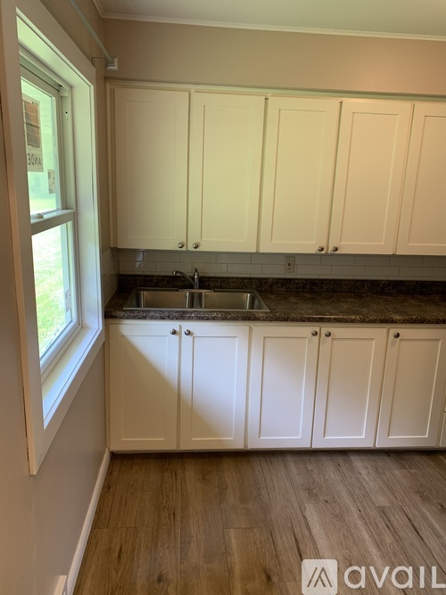 A kitchen with white cabinets and a granite countertop.