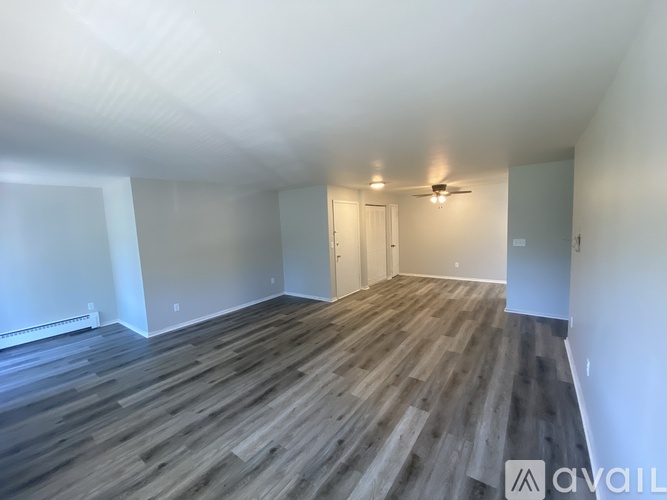 A room with wooden flooring and a ceiling fan.