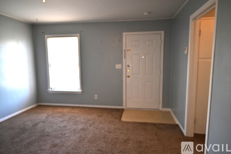 A room with a carpeted floor and a white door.