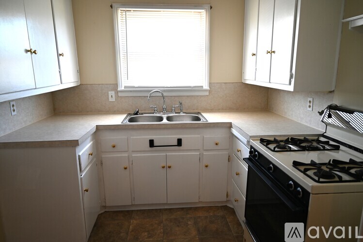 A kitchen with white cabinets and a black stove top oven.