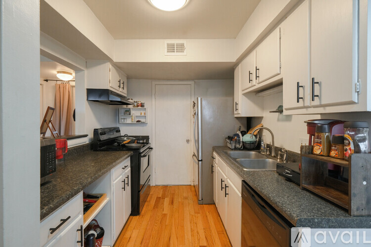 A kitchen with black appliances and white cabinets.