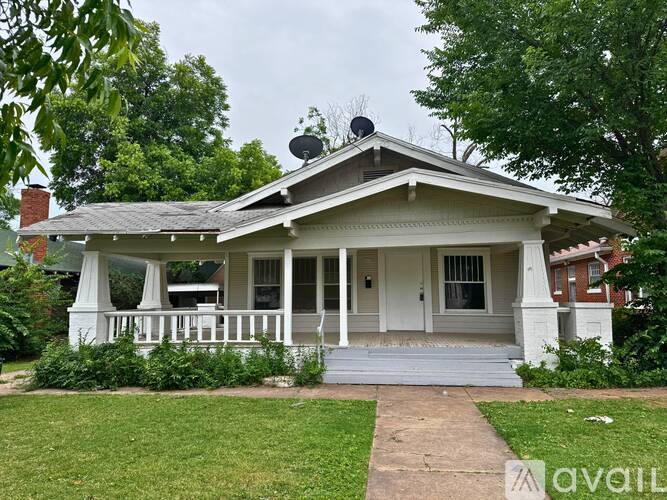 A white house with a porch and a covered patio.