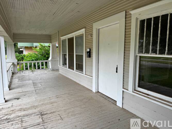 A porch with a white door and a window.