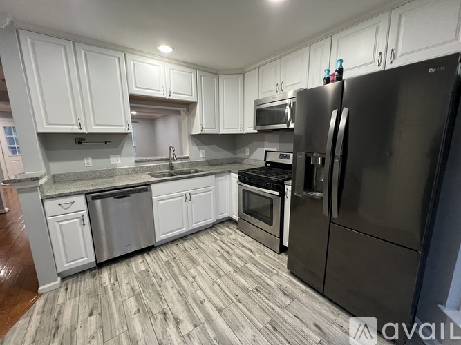 A kitchen with a refrigerator, oven, and microwave.