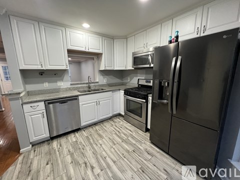 A kitchen with a refrigerator, oven, and microwave.