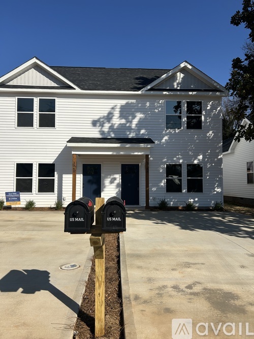 A white house with a mailbox in front.