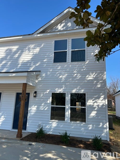 A white house with a blue door and windows.