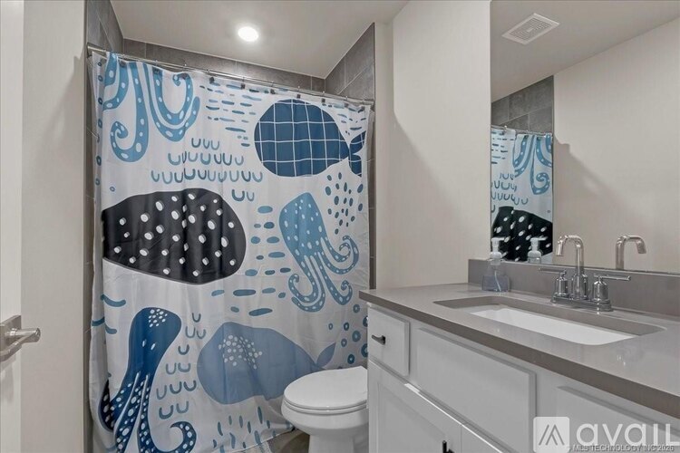 A bathroom with a shower curtain featuring an octopus and bubbles.