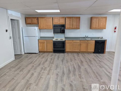 A kitchen with wooden cabinets and a white refrigerator.