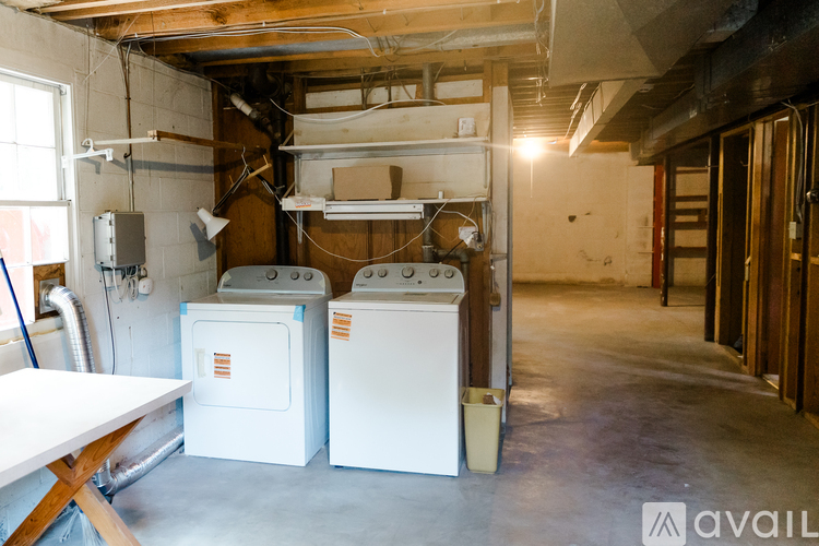 A room with a white table and two white ovens.