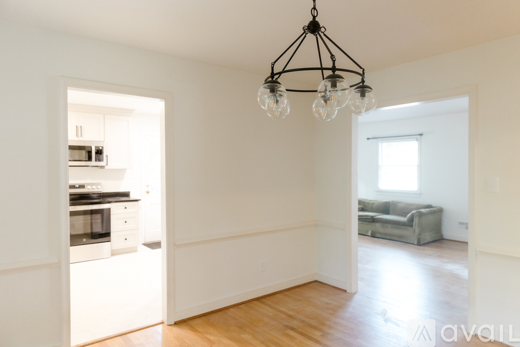 A living room with a kitchen in the background and a couch in the living room.