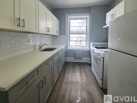 A kitchen with white appliances and wooden floors.