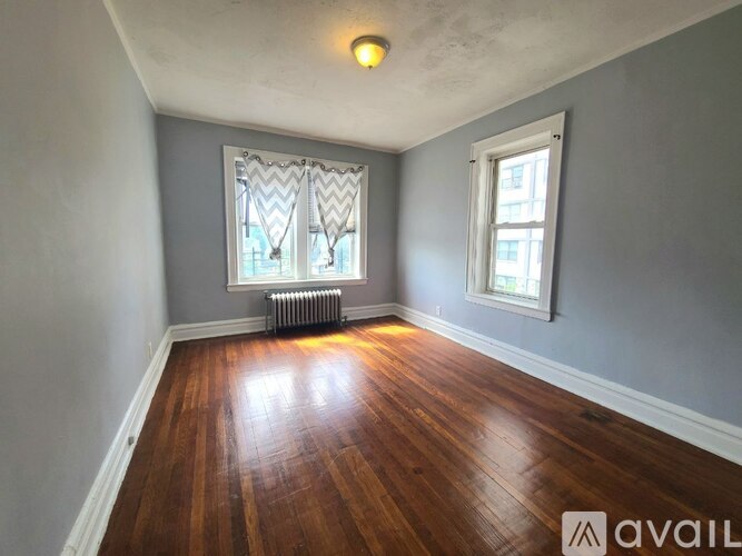 A room with wooden floors and two windows.