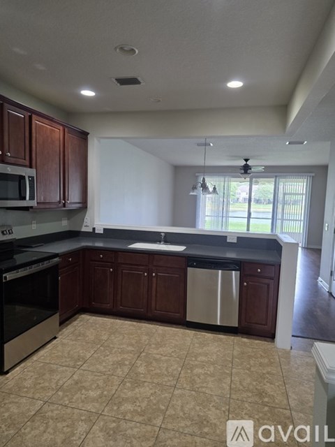 A kitchen with brown cabinets and a black countertop.