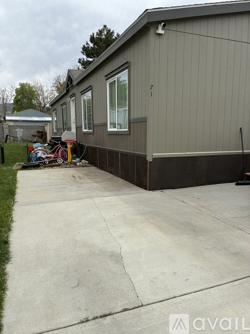 A grey house with a white door and a grey garage door.
