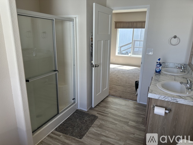 A bathroom with a sink, mirror, and shower.