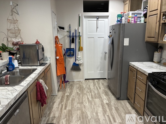 A kitchen with a white door and a grey refrigerator.