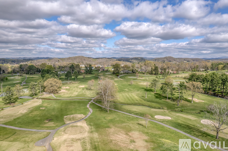A golf course with a winding path and green grass.