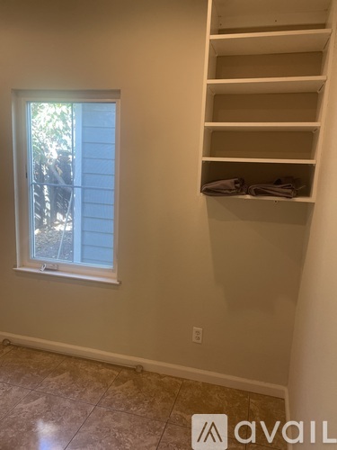 A wall with a shelf and a window.