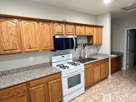 A kitchen with wooden cabinets and a white stove top oven.