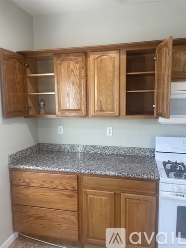 A kitchen with wooden cabinets and a granite countertop.