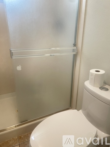 A toilet with a roll of toilet paper on it.