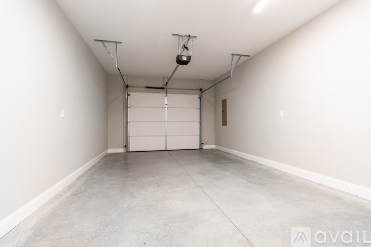 A large empty room with a garage door in the middle.