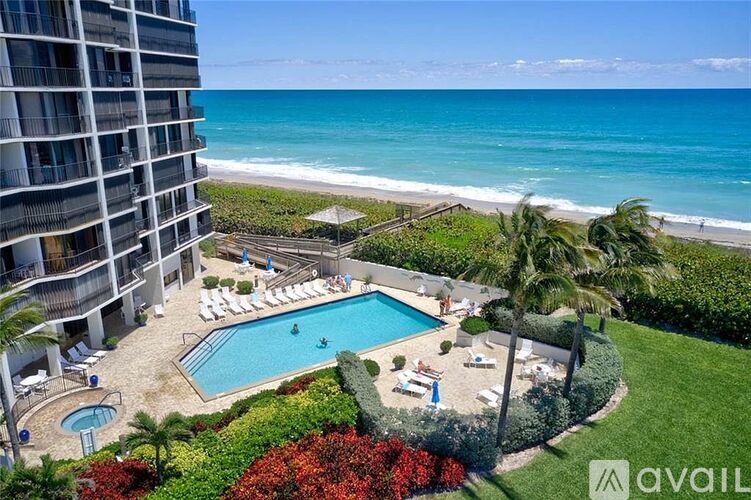 A view of a pool and beach from a balcony.