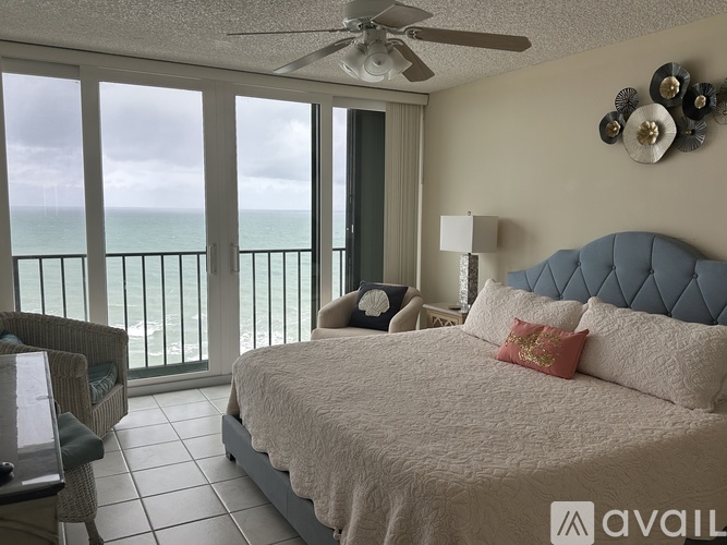 A bedroom with a large bed and a view of the ocean.