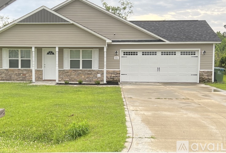 A house with a garage and a driveway in front.