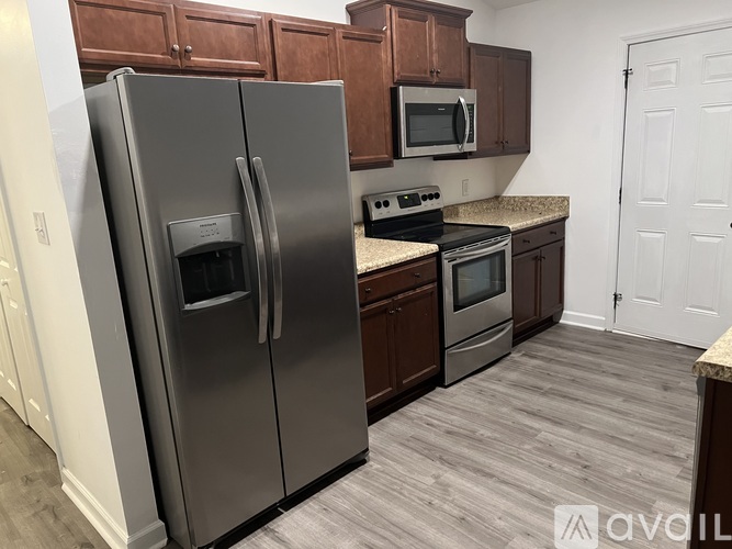 A kitchen with a refrigerator, microwave, oven, and stove.