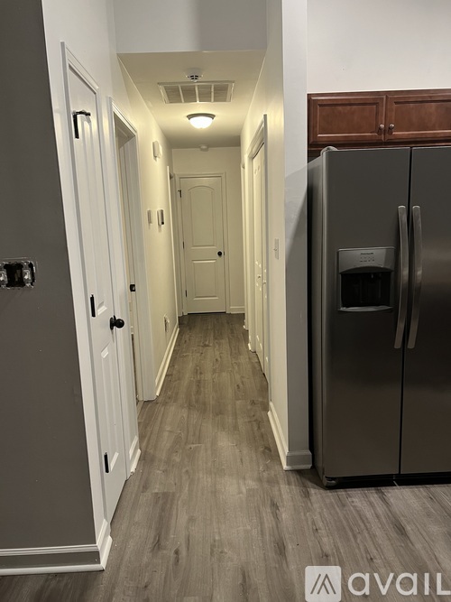 A long hallway with a refrigerator on the right.