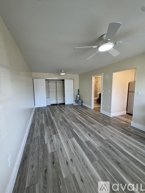 A room with wooden flooring and a ceiling fan.
