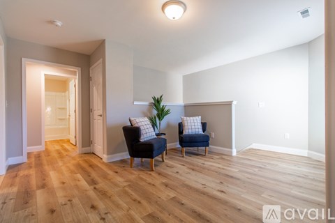 A living room with two chairs and a plant.