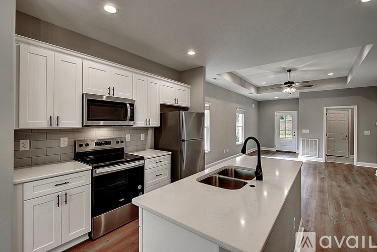 A modern kitchen with white cabinets and stainless steel appliances.