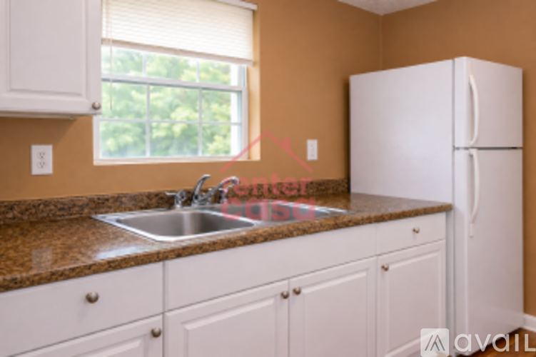 A kitchen with brown countertops and white cabinets.