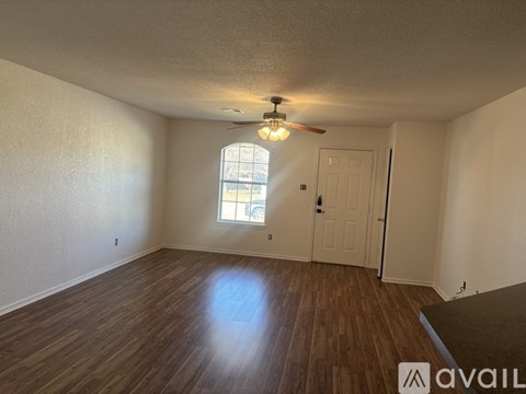 A room with wooden flooring and a ceiling fan.