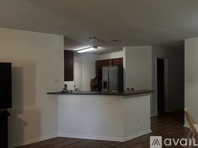 A kitchen with white walls and a wooden floor.