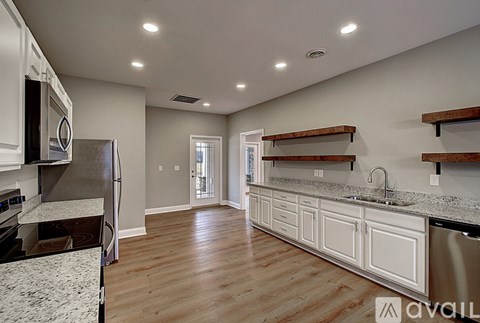 A kitchen with white cabinets and a refrigerator.