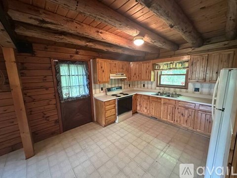 A kitchen with wooden cabinets and a tiled floor.