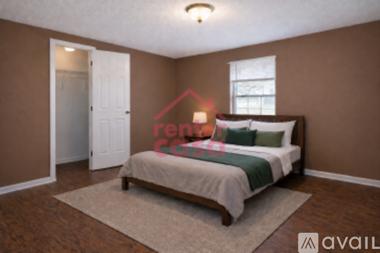 A bedroom with a bed, a rug, and a window.