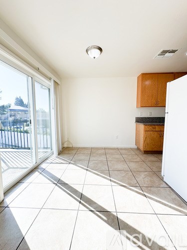 A kitchen with a white refrigerator and wooden cabinets.
