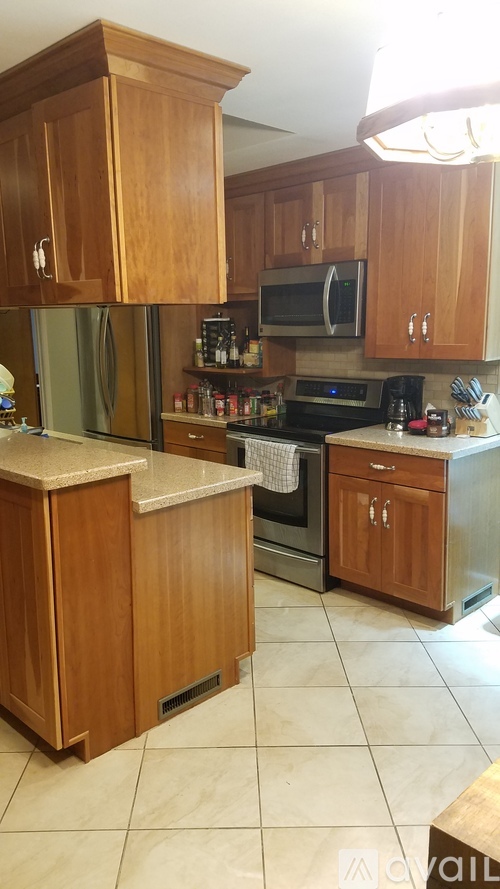 A kitchen with wooden cabinets and a white counter.
