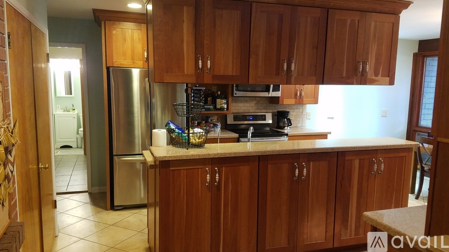 A kitchen with wooden cabinets and a stainless steel refrigerator.