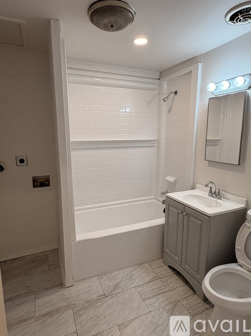 A bathroom with a toilet, sink, and bathtub.