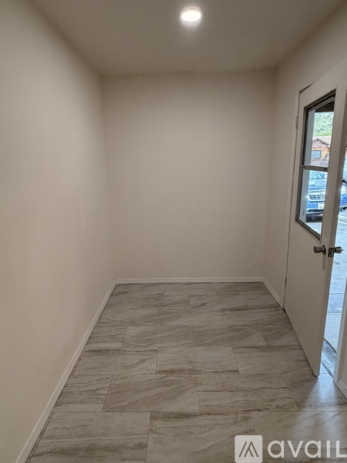 A room with a tiled floor and a door leading outside.