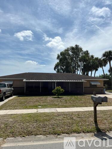 A house with a car parked in front and a mailbox on the right.