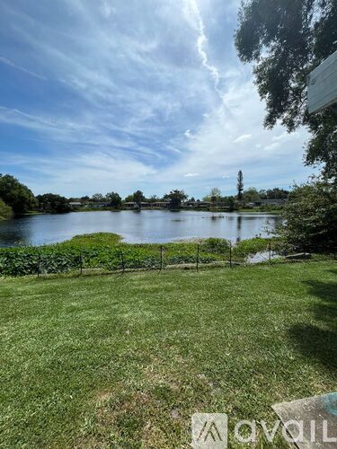 A grassy field with a body of water and a tower in the distance.