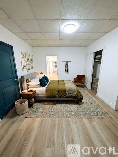 A bedroom with a bed, a chair, and pictures on the wall.