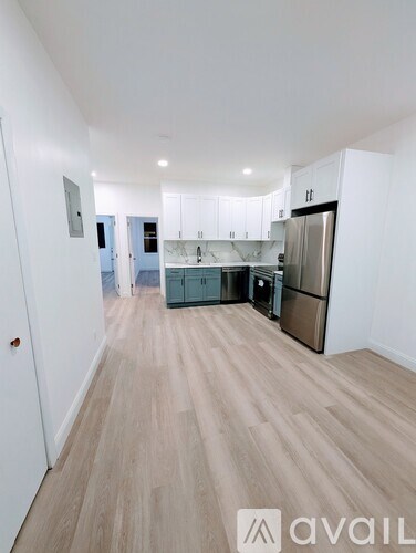 A kitchen with white cabinets and a wooden floor.